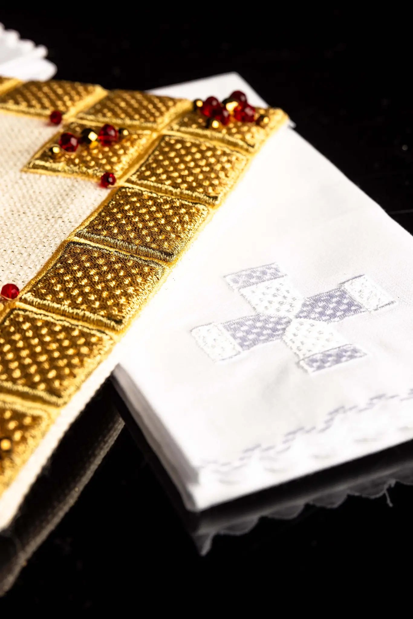 Ecru handmade chalice linen set with a pall featuring a dimensional gold cross, red hematite, and shimmering crystals, a corporal with a central cross, and a purificator and lavabo towel with embroidered crosses, all with scalloped edges.