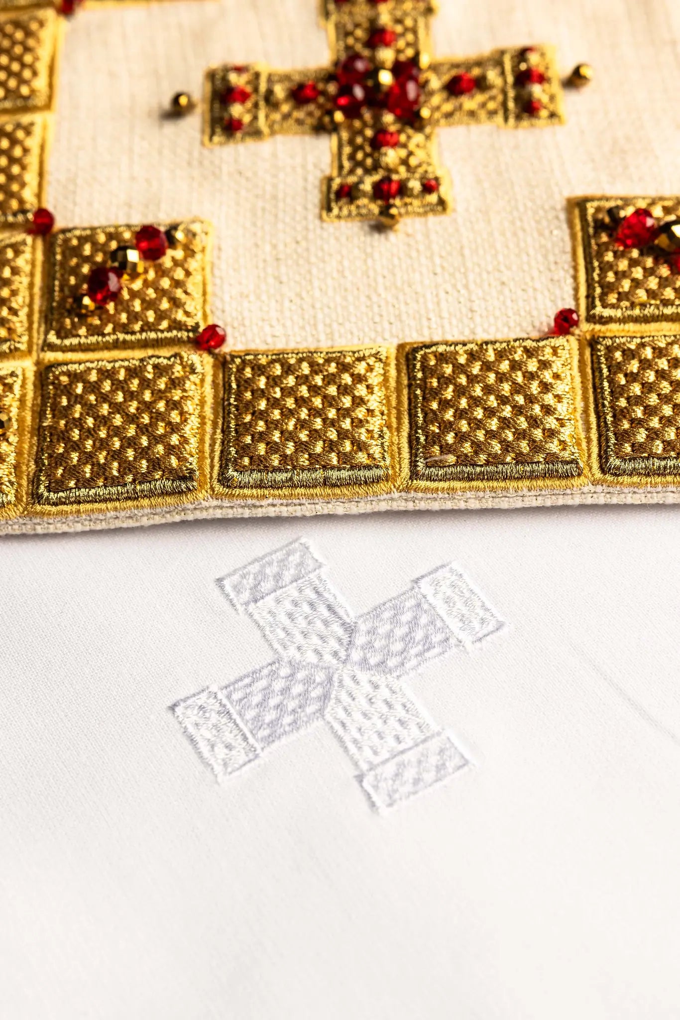 Ecru handmade chalice linen set with a pall featuring a dimensional gold cross, red hematite, and shimmering crystals, a corporal with a central cross, and a purificator and lavabo towel with embroidered crosses, all with scalloped edges.