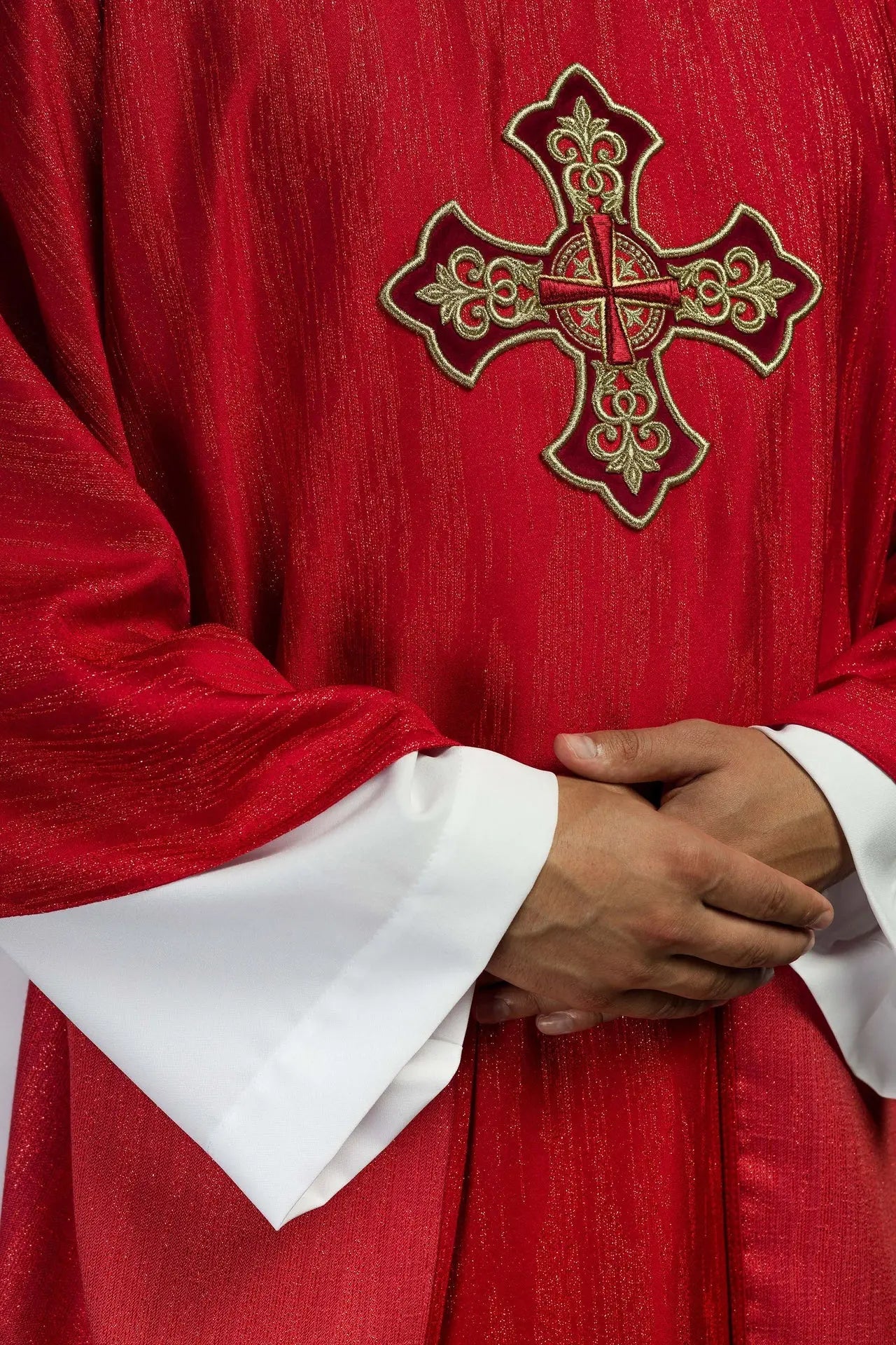 Red chasuble with embroidered cross motif on decorative fabric
