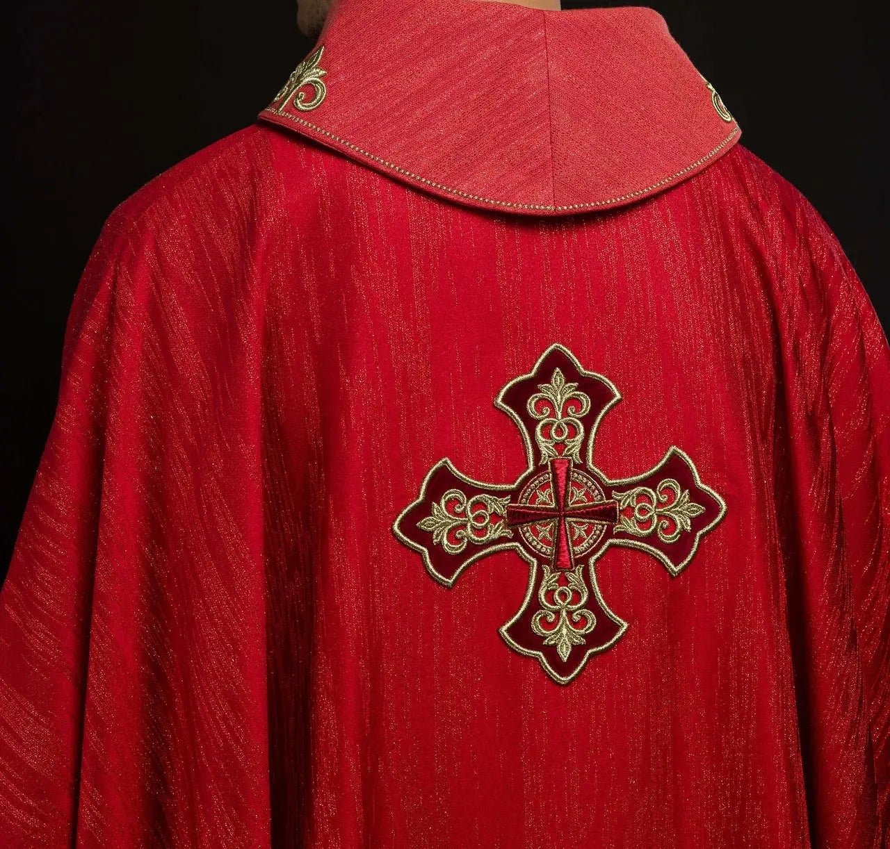 Red chasuble with embroidered cross motif on decorative fabric
