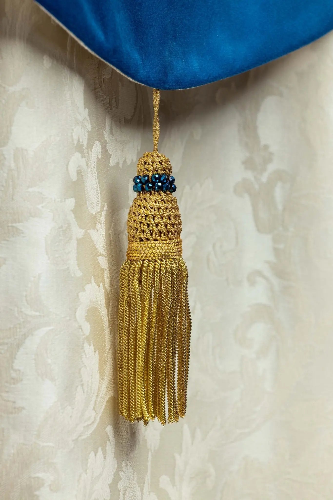 Ecru Marian cope with natural stones and blue velvet trim, part of the Handmade Collection, featuring an ornate metal clasp and gold tassel.