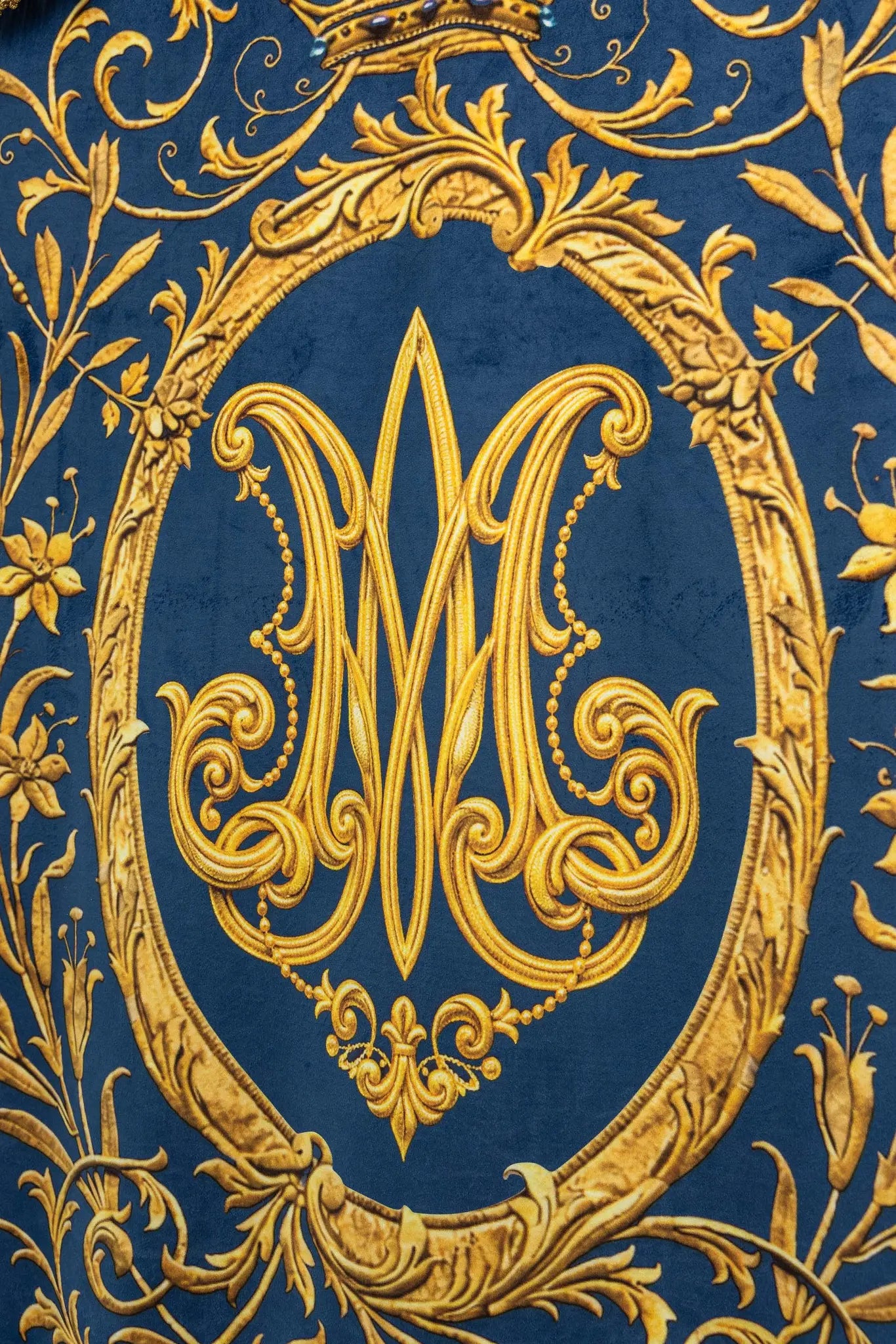 Double-sided blue processional banner with an image of Our Lady of the Immaculate Conception on one side and a Marian monogram on the other, both surrounded by gold floral ornamentation and finished with gold fringes.