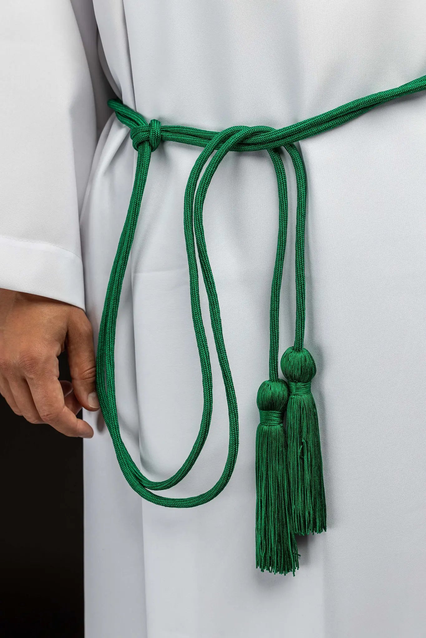 Green liturgical cincture with decorative tassels, made from braided cord.
