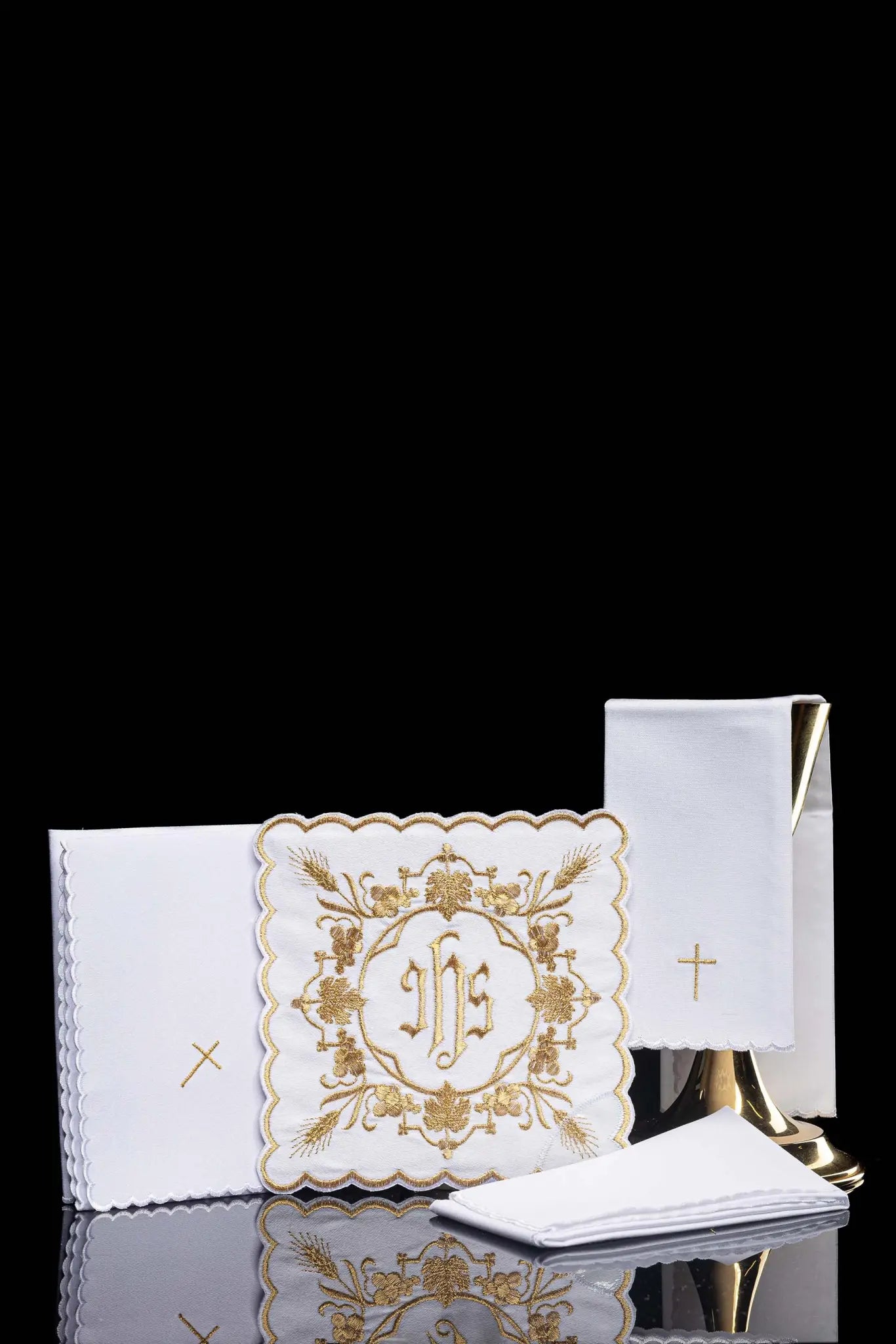 White chalice linen set with IHS embroidery on pall, purificator, and lavabo towel.