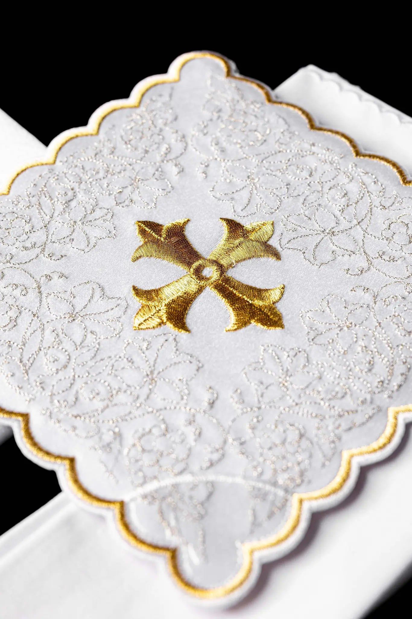 White chalice linen set with gold embroidered cross motif, including pall, corporal, purificator, and lavabo towel.