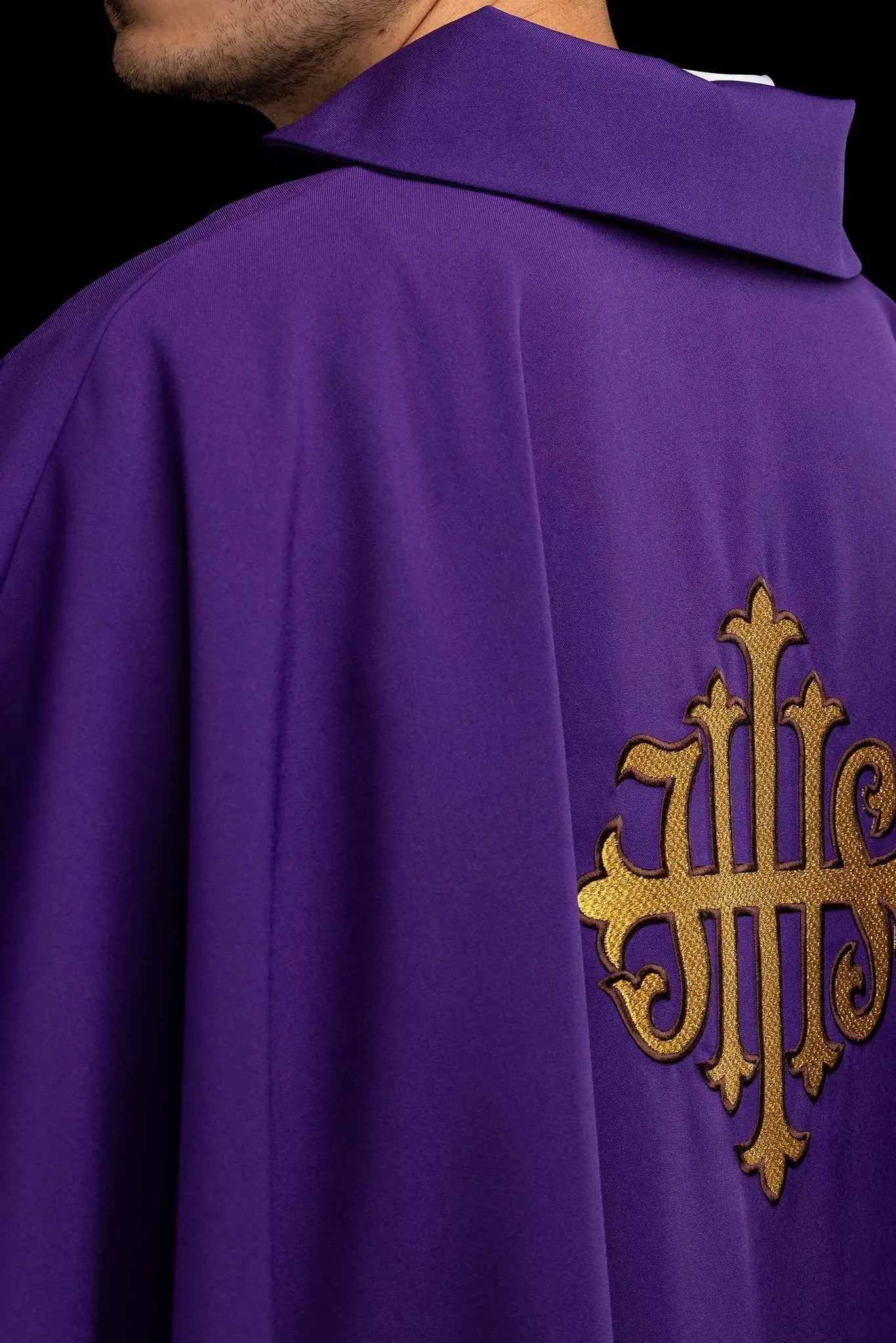 Purple chasuble with embroidered IHS symbol and gold trim, featuring a V-neckline and a matching stole.