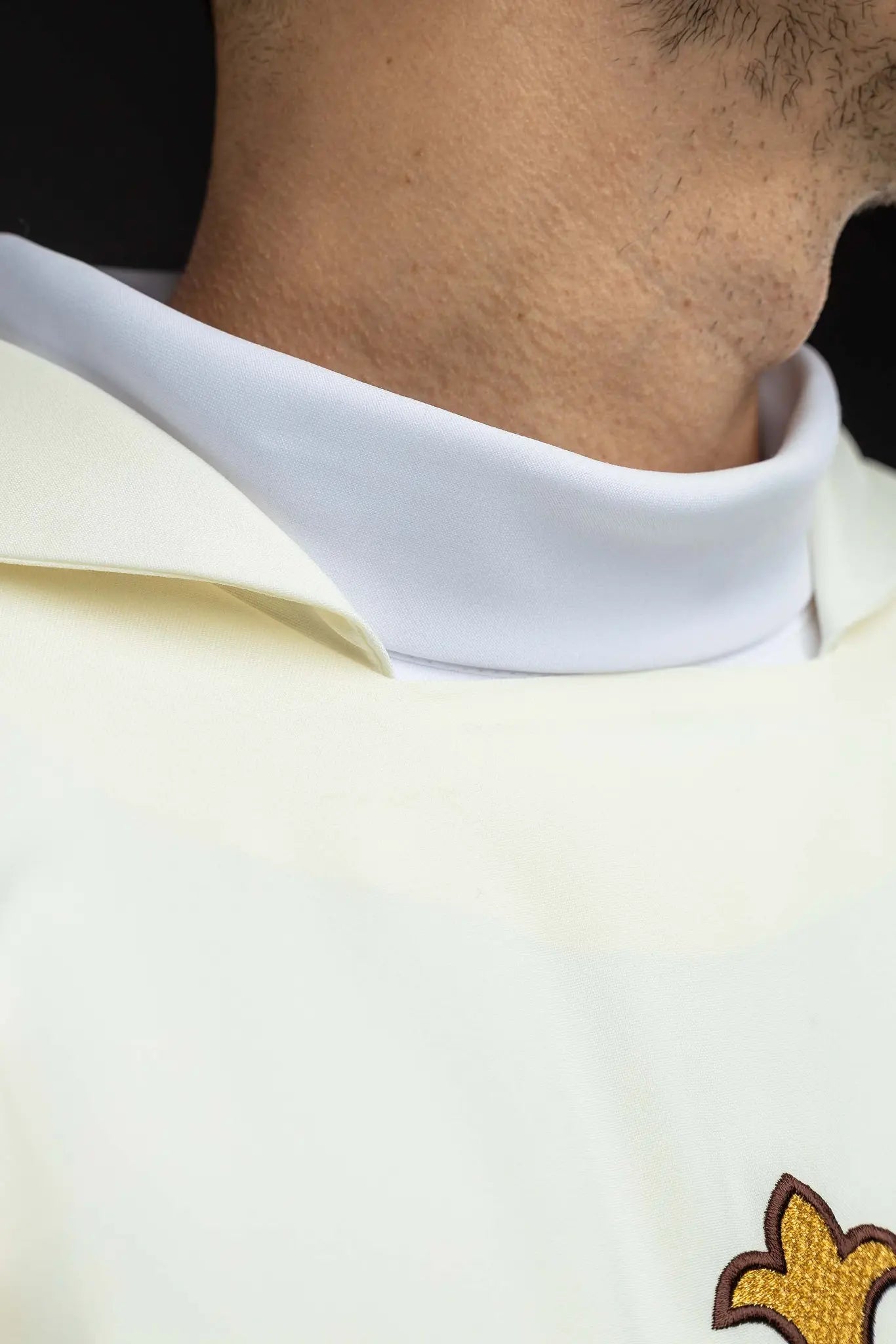 Ecru chasuble with gold IHS embroidery and gold trim, featuring a V-neck collar.