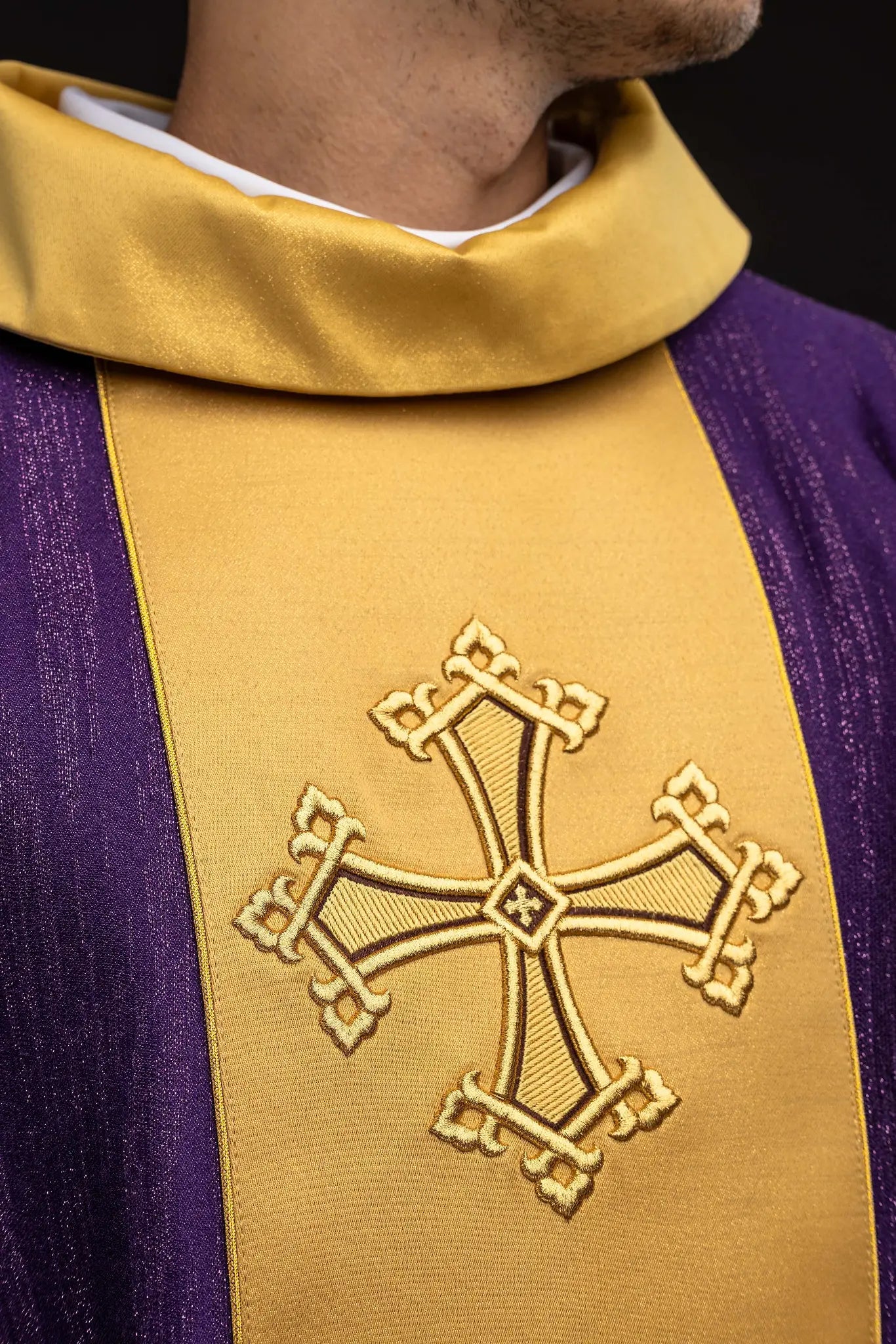 Purple chasuble with a vertical gold band featuring embroidered stylized crosses, gold trim on sleeves and collar, and a stand-up collar.