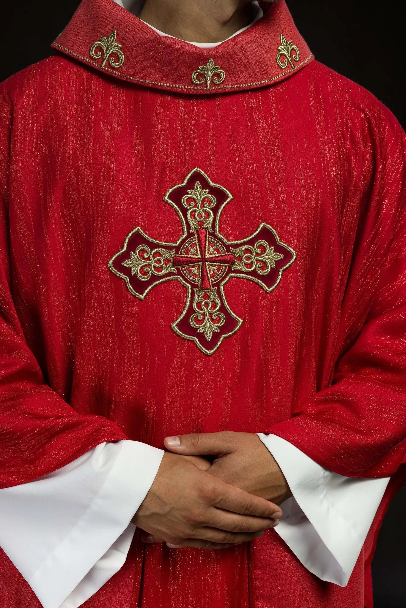 Red chasuble with embroidered cross motif on decorative fabric