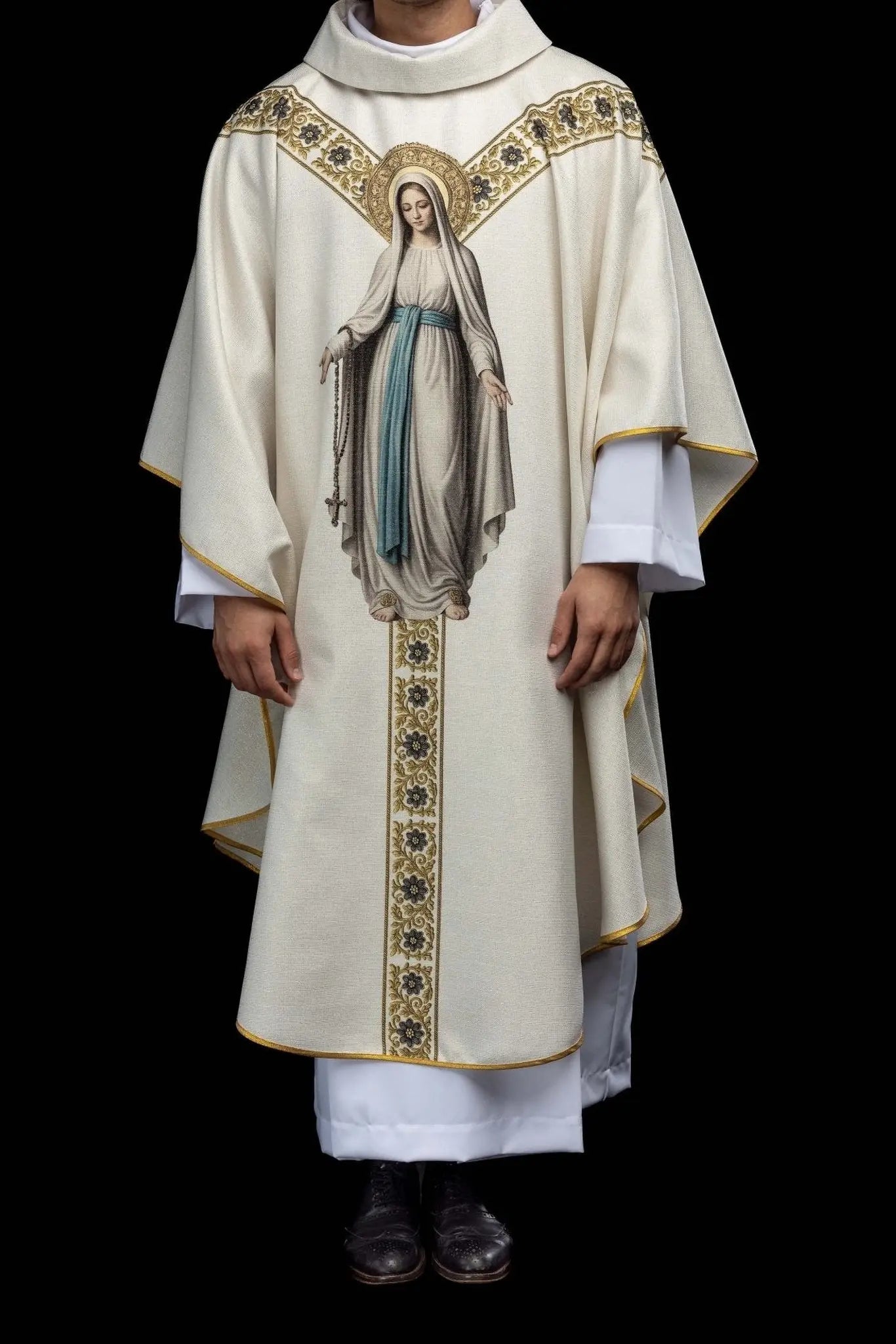 Ecru chasuble with printed image of Our Lady of Lourdes, featuring a blue sash and gold floral motifs, with a matching stole.