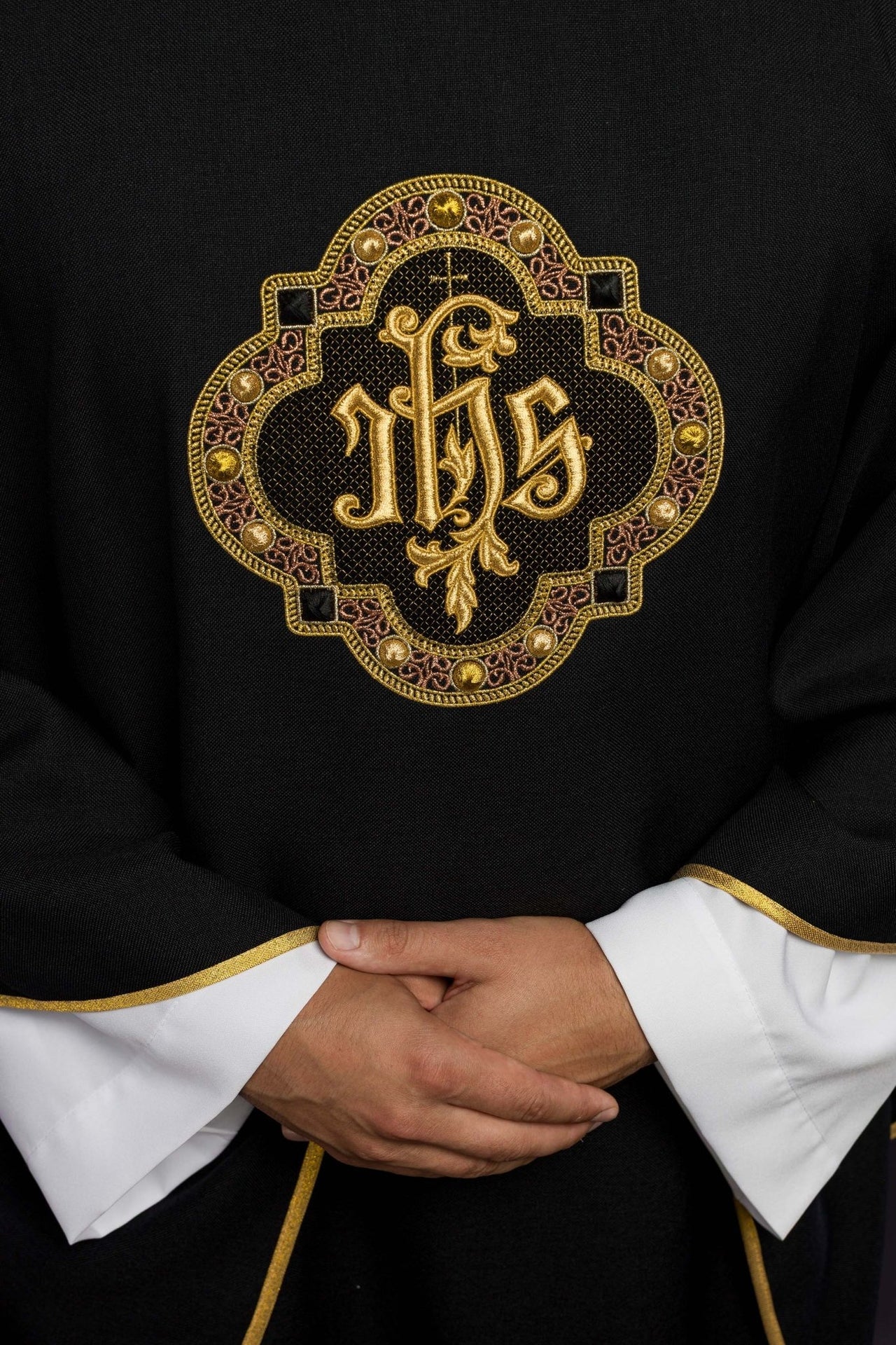 Ornat z bogato haftowanym pasem i lamówką wokół haft IHS I kołnierza w kolorze czarnym