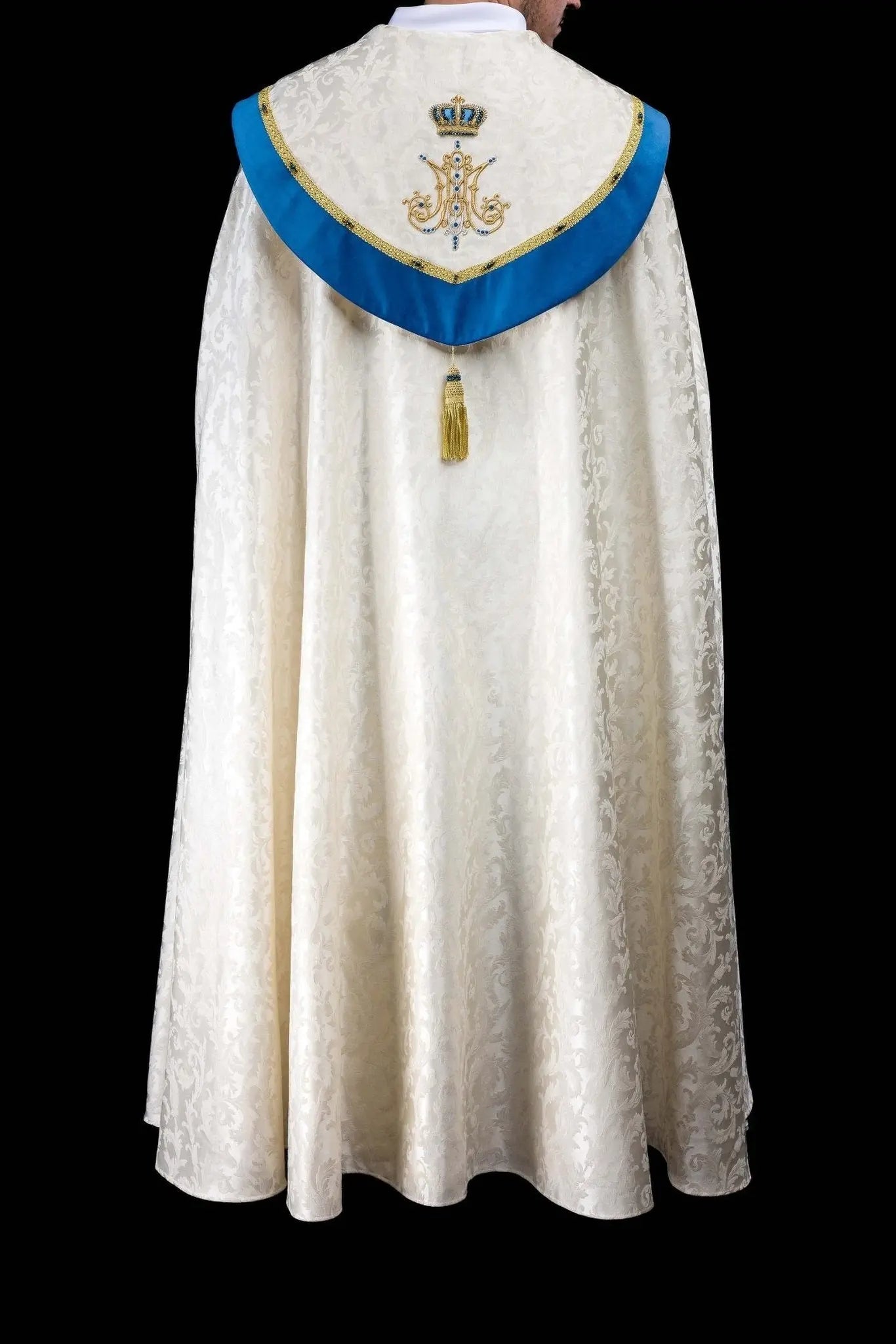 Ecru Marian cope with natural stones and blue velvet trim, part of the Handmade Collection, featuring an ornate metal clasp and gold tassel.